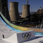 
              A worker shapes the kicker at the Big Air Shougang ahead of the 2022 Winter Olympics, Feb. 1, 2022, in Beijing, as the old cooling towers of a steel plant stand in the city's former industrial district. (AP Photo/Jae C. Hong)
            