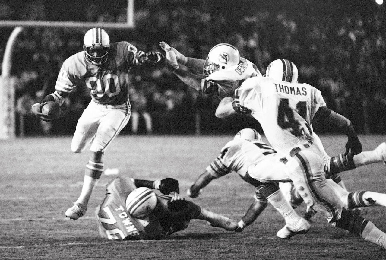 FILE - Miami Dolphin defenders Vern Den Herder and Norris Thomas (41) go after Houston Oilers wide ...