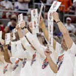 
              Auburn head coach Bruce Pearl and players hold up signs remembering those who have battled cancer before the start of an NCAA college basketball game against Texas A&M Saturday, Feb. 12, 2022, in Auburn, Ala. (AP Photo/Butch Dill)
            