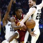 
              Cleveland Cavaliers' Rajon Rondo (1) passes between San Antonio Spurs' Joshua Primo (11) and Jakob Poeltl (25) during the first half of an NBA basketball game, Wednesday, Feb. 9, 2022, in Cleveland. (AP Photo/Ron Schwane)
            