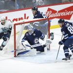 
              Seattle Kraken's Jordan Eberle (7) looks for Marcus Johansson (90) as he attempts to make a pass in front of Winnipeg Jets goaltender Eric Comrie (1) during the second period of an NHL hockey game Thursday, Feb. 17, 2022 in Winnipeg, Manitoba. (John Woods/The Canadian Press via AP)
            