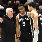 
              San Antonio Spurs head coach Gregg Popovich, left, talks with forward Keldon Johnson (3) and Doug McDermott during the first half of an NBA basketball game against the Chicago Bulls, Monday, Feb. 14, 2022, in Chicago. (AP Photo/Charles Rex Arbogast)
            