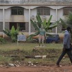 
              A man walk past The Statue of Late Cameroonian soccer star Marc-Vivien Foé, outside his abandoned soccer academy in Yaounde, Cameroon, Wednesday Feb. 2, 2022. The late Cameroon star Marc-Vivien Foé had a dream to build a soccer academy in his hometown, his gift to his country and his people. He never got to finish it after collapsing on a field playing for his country in 2003 and dying of a heart condition at the age of 28. (AP Photo/Sunday Alamba)
            