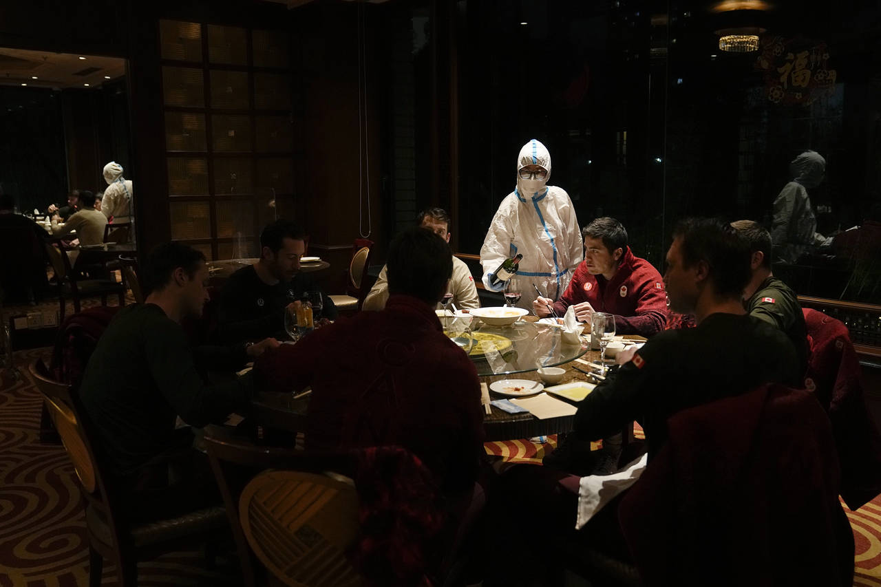 A waitress serves a table in protective gear in a restaurant inside the Shangri-La Hotel at the 202...