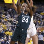 
              Michigan State guard Nia Clouden (24) gets past Michigan center Izabel Varejao to shoot during the second half of an NCAA college basketball game Thursday, Feb. 24, 2022, in Ann Arbor, Mich. (AP Photo/Duane Burleson)
            