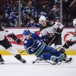 
              Vancouver Canucks' Conor Garland (8) falls while skating with the puck in front of Arizona Coyotes' Ilya Lyubushkin, Travis Boyd and Antoine Roussel, from left, during the third period of an NHL hockey game Tuesday, Feb. 8, 2022, in Vancouver, British Columbia. (Darryl Dyck/The Canadian Press via AP)
            