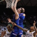 
              Kansas guard Christian Braun, center, shoots as Baylor forward Jeremy Sochan, left, and guard James Akinjo, right, watch from below during the first half of an NCAA college basketball game Saturday, Feb. 26, 2022, in Waco, Texas. (AP Photo/Ray Carlin)
            