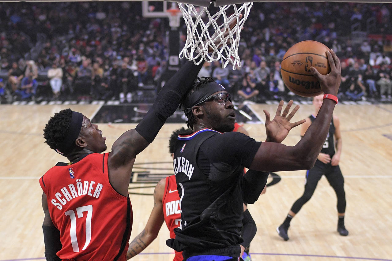 Los Angeles Clippers guard Reggie Jackson, right, shoots as Houston Rockets guard Dennis Schroder d...