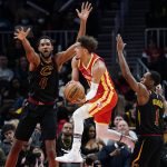 
              Atlanta Hawks guard Trae Young (11) looks to pass the ball as Cleveland Cavaliers' Evan Mobley (4) and Rajon Rondo (1) defend during the second half of an NBA basketball game Tuesday, Feb. 15, 2022, in Atlanta. (AP Photo/John Bazemore)
            