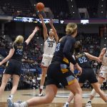 
              Connecticut's Caroline Ducharme (33) shoots over Marquette's Liza Karlen (32) during the first half of an NCAA college basketball game Wednesday, Feb. 23, 2022, in Hartford, Conn. (AP Photo/Jessica Hill)
            