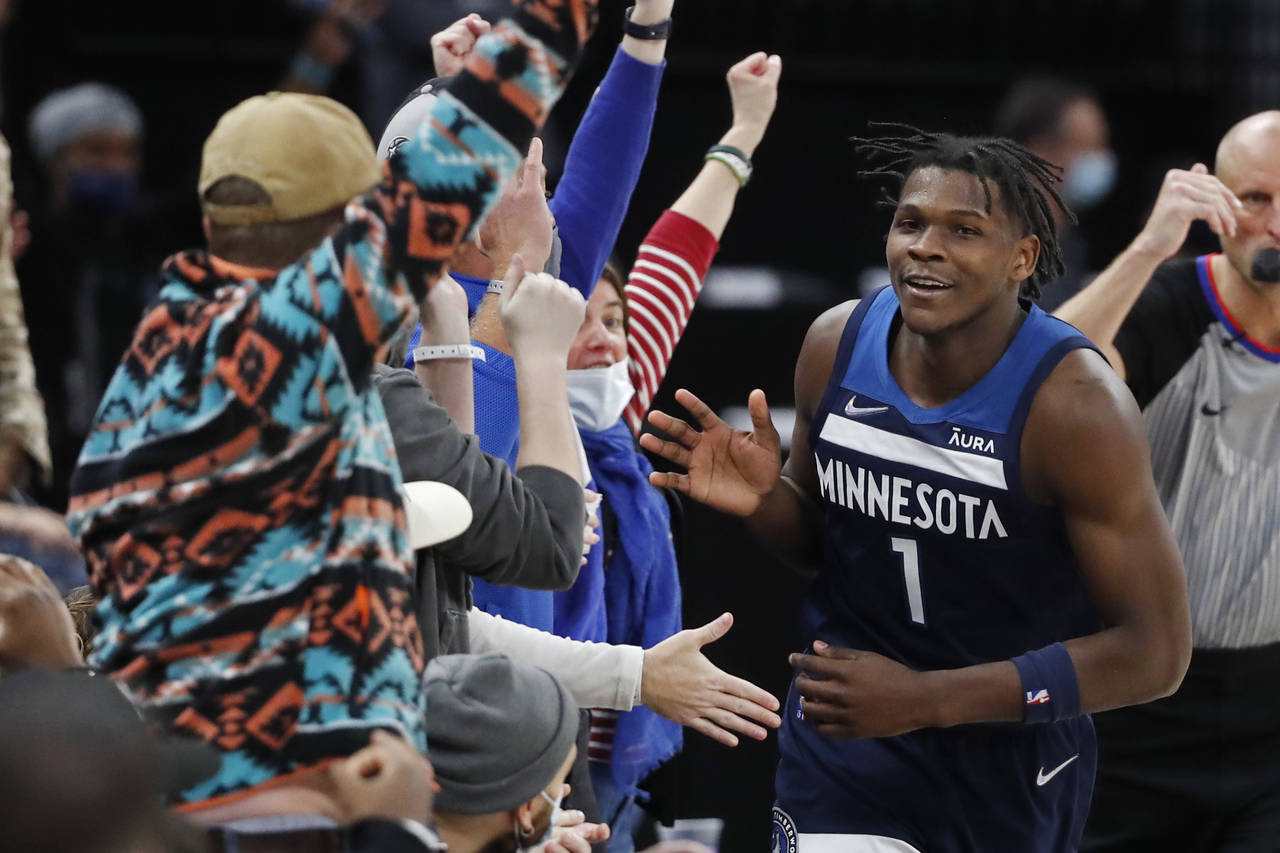 Minnesota Timberwolves forward Anthony Edwards celebrates his 3-pointer with fans in the last minut...