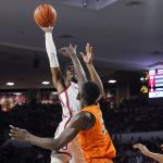 
              Oklahoma guard Marvin Johnson, left, shoots over Oklahoma State forward Moussa Cisse, center, in the second half of an NCAA college basketball game Saturday, Feb. 26, 2022, in Norman, Okla. (AP Photo/Sue Ogrocki)
            
