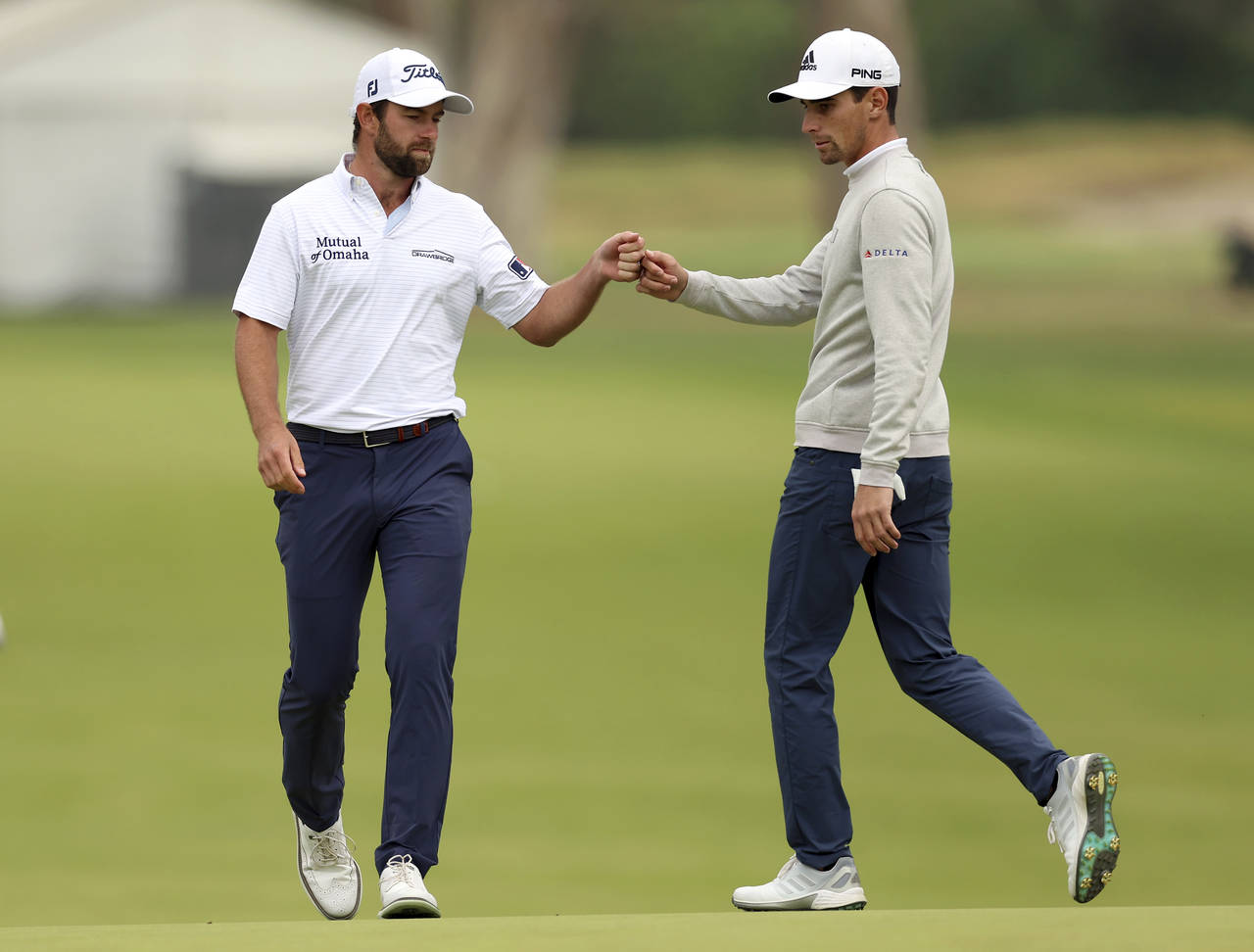 Cameron Young, left, fist-bumps Joaquin Niemann, of Chile, after hitting in for birdie on the 15th ...