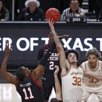 
              Texas' Christian Bishop (32) tips the ball off over Texas Tech's Bryson Williams (11) during the first half of an NCAA college basketball game on Tuesday, Feb. 1, 2022, in Lubbock, Texas. (AP Photo/Brad Tollefson)
            