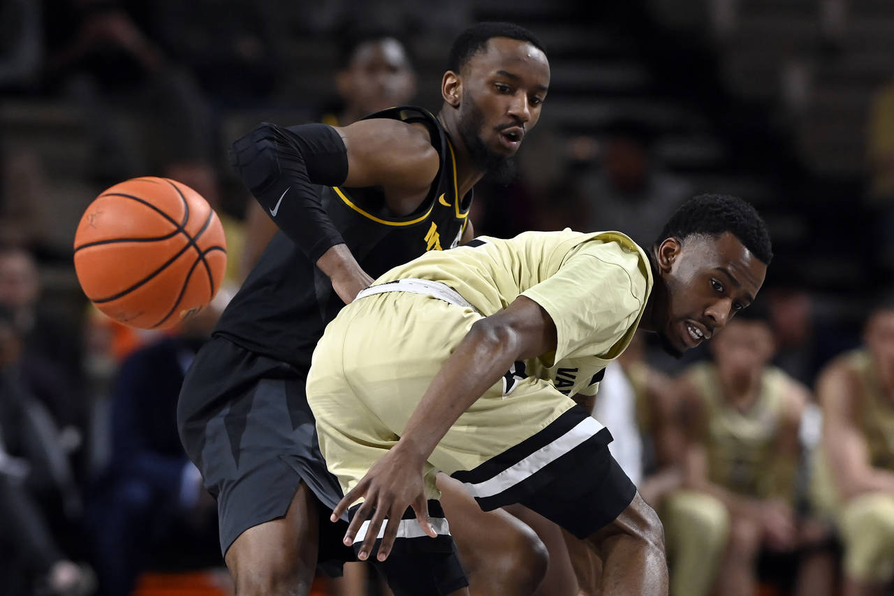 Vanderbilt guard Trey Thomas, right, loses control of the ball as he is defended by Missouri guard ...