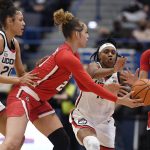 
              St. John's Rayven Peeples (20) passes to Leilani Correa (2) as Connecticut's Olivia Nelson-Ododa (20) and Christyn Williams (13) defend during the first half of an NCAA college basketball game Friday, Feb. 25, 2022, in Hartford, Conn. (AP Photo/Jessica Hill)
            