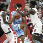 
              North Carolina guard Puff Johnson (14) grabs a rebound against North Carolina State guard Dereon Seabron (1) and forward Ebenezer Dowuona, right, during the second half of an NCAA college basketball game in Raleigh, N.C., Saturday, Feb. 26, 2022. (AP Photo/Gerry Broome)
            