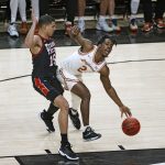 
              Texas' Marcus Carr (2) dribbles the ball around Texas Tech's Kevin McCullar (15) during the first half of an NCAA college basketball game on Tuesday, Feb. 1, 2022, in Lubbock, Texas. (AP Photo/Brad Tollefson)
            
