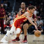 
              Atlanta Hawks guard Trae Young (11) is fouled by Cleveland Cavaliers forward Isaac Okoro (35) during the second half of an NBA basketball game Tuesday, Feb. 15, 2022, in Atlanta. (AP Photo/John Bazemore)
            