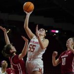 
              Maryland forward Chloe Bibby (55) goes up for a basket against Wisconsin guard Katie Nelson, left, and guard Halle Douglass (10) during the second half of an NCAA college basketball game, Wednesday, Feb. 9, 2022, in College Park, Md. Maryland won 70-43. (AP Photo/Julio Cortez)
            