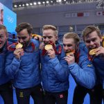 
              Gold medalists Team Sweden bite their medals during the medal ceremony for the men's curling at the Beijing Winter Olympics Saturday, Feb. 19, 2022, in Beijing. (AP Photo/Brynn Anderson)
            