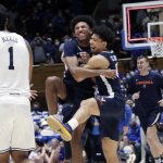 
              Virginia guard Reece Beekman, center left, celebrates with guard Kihei Clark (0) while Duke guard Trevor Keels (1) looks on as the clock runs out at the end of an NCAA college basketball game against Duke, Monday, Feb. 7, 2022, in Durham, N.C. Beekman hit a 3-point shot with under three seconds for the go-ahead and eventual game-winning points. (AP Photo/Chris Seward)
            