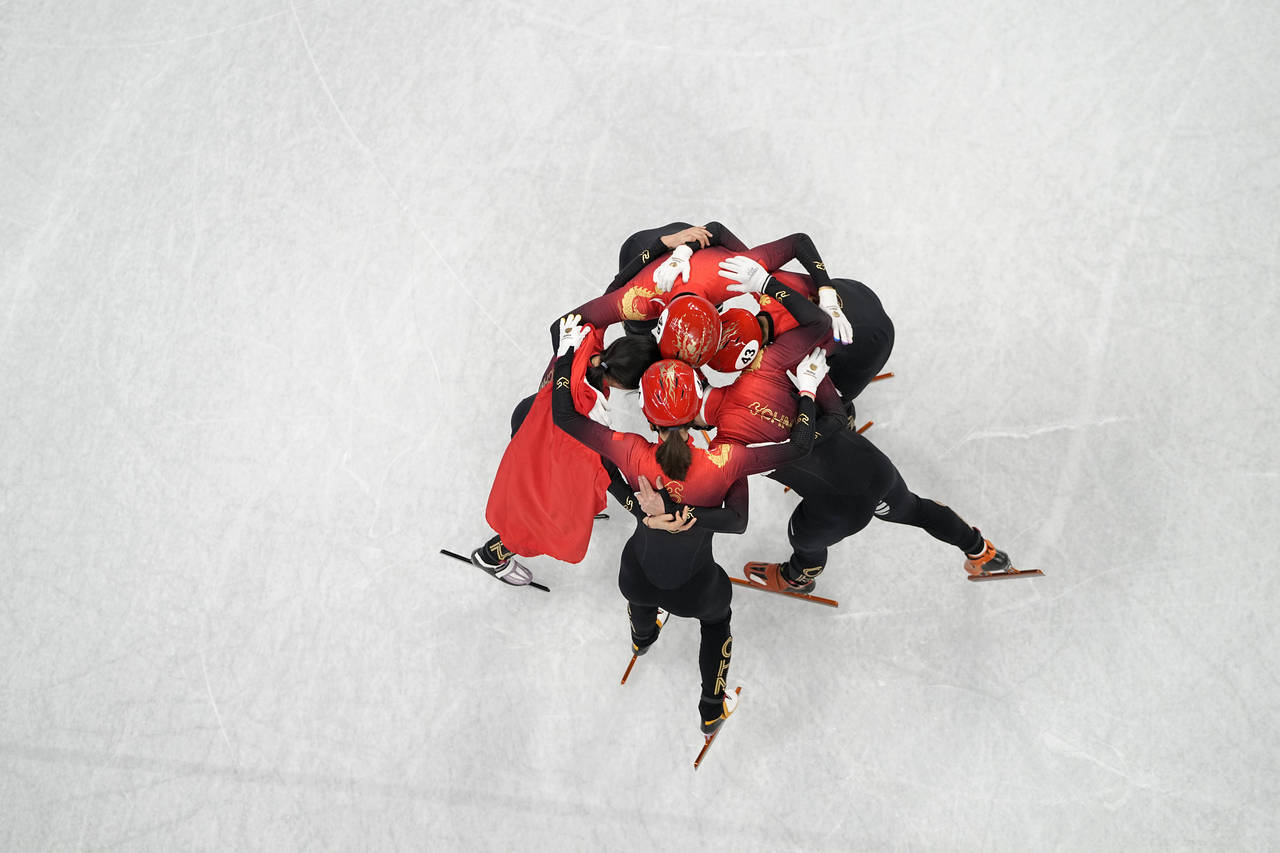 Skaters from China hug in celebration after winning the final to earn a gold medal in the mixed rel...