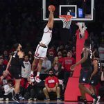 
              St. John's Julian Champagnie, top, slam dunks the ball during the first half of an NCAA college basketball game against Connecticut Sunday, Feb. 13, 2022, in New York. (AP Photo/Seth Wenig)
            
