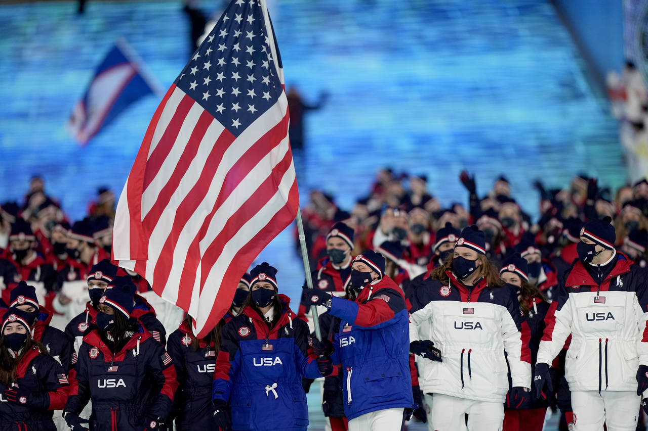 Brittany Bowe and John Shuster, of the United States, lead their team in during the opening ceremon...