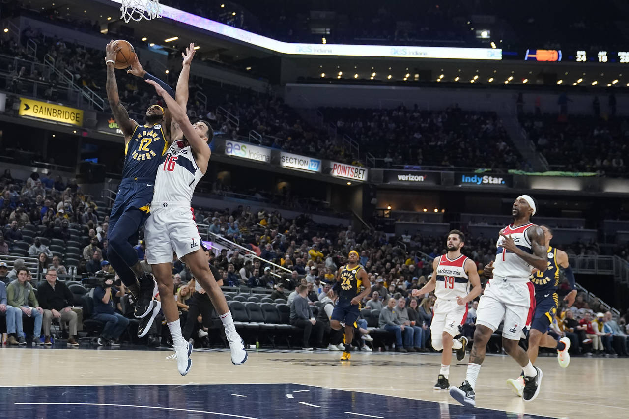 Indiana Pacers' Oshae Brissett (12) is fouled by Washington Wizards' Anthony Gill (16) during the f...