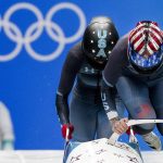 
              Kaillie Humphries and Kaysha Love, of the United States, start the women's bobsleigh heat 3 at the 2022 Winter Olympics, Saturday, Feb. 19, 2022, in the Yanqing district of Beijing. (AP Photo/Dmitri Lovetsky)
            