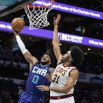 
              Charlotte Hornets forward Miles Bridges (0) drives to the basket while guarded by Cleveland Cavaliers center Jarrett Allen (31) during the first half of an NBA basketball game in Charlotte, N.C., Friday, Feb. 4, 2022. (AP Photo/Jacob Kupferman)
            