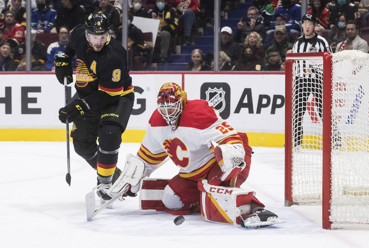 Vancouver Canucks' J.T. Miller (9) watches the rebound after Calgary Flames goalie Jacob Markstrom ...