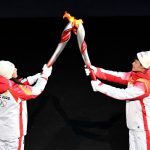 
              A torchbearer transfers flame to another during the opening ceremony of the 2022 Winter Olympics, Friday, Feb. 4, 2022, in Beijing. (Anthony Wallace/Pool Photo via AP)
            