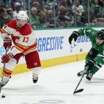 
              Calgary Flames left wing Johnny Gaudreau (13) controls the puck in front of Dallas Stars defenseman Jani Hakanpaa (2) in the second period of an NHL hockey game in Dallas, Tuesday, Feb. 1, 2022. (AP Photo/Tony Gutierrez)
            