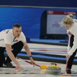 
              Norway's Magnus Nedregotten, left, throws a rock as teammate Kristin Skaslien, sweeps during the mixed doubles gold medals curling match against Italy at the Beijing Winter Olympics Tuesday, Feb. 8, 2022, in Beijing. (AP Photo/Brynn Anderson)
            
