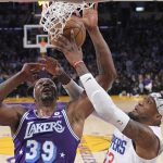
              Los Angeles Lakers center Dwight Howard, left, shoots as Los Angeles Clippers forward Robert Covington blocks the shot during the first half of an NBA basketball game Friday, Feb. 25, 2022, in Los Angeles. (AP Photo/Mark J. Terrill)
            