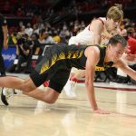 
              Iowa guard Payton Sandfort, front, dives for the ball past Maryland guard Aidan McCool during the second half of an NCAA college basketball game, Thursday, Feb. 10, 2022, in College Park, Md. (AP Photo/Nick Wass)
            