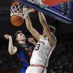 
              Florida forward Colin Castleton (12) tries to block Auburn forward Walker Kessler (13) during the first half of an NCAA college basketball game Saturday, Feb. 19, 2022, in Gainesville, Fla. (AP Photo/Alan Youngblood)
            