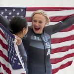 
              Kaillie Humphries, of the United States, right, and teammate Elana Meyers Taylor celebrate winning the gold and silver medals in the women's monobob at the 2022 Winter Olympics, Monday, Feb. 14, 2022, in the Yanqing district of Beijing. (AP Photo/Pavel Golovkin)
            