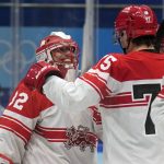 
              Denmark goalkeeper Sebastian Dahm (32) is congratulated after a win over Czech Republic during a preliminary round men's hockey game at the 2022 Winter Olympics, Wednesday, Feb. 9, 2022, in Beijing. (AP Photo/Petr David Josek)
            