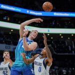 
              Charlotte Hornets center Mason Plumlee passes the ball over Dallas Mavericks forward Sterling Brown (0) as Mavericks forward Maxi Kleber (42) watches during the first half of an NBA basketball game on Saturday, March 19, 2022, in Charlotte, N.C. (AP Photo/Rusty Jones)
            