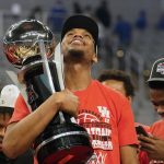 
              Houston forward Fabian White Jr. holds the championship trophy after an NCAA college basketball game against Memphis for the American Athletic Conference tournament championship in Fort Worth, Texas, Sunday, March 13, 2022. (AP Photo/LM Otero)
            