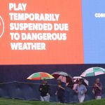 
              Fans take cover after play was suspended because of bad waerther during the first round of play in the Players Championship golf tournamnet Thursday, March 10, 2022, in Ponte Vedra Beach, Fla. (AP Photo/Lynne Sladky)
            