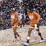 
              Two Texas players make their way through a confetti shower for the awards ceremony after they beat Baylor for the Big 12 championship in an NCAA college basketball game in Kansas City, Mo., Sunday, March 13, 2022. (AP Photo/Reed Hoffmann)
            