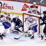 
              Winnipeg Jets goaltender Connor Hellebuyck (37) makes a save on Montreal Canadiens' Brendan Gallagher (11) during the third period of an NHL hockey game Tuesday, March 1, 2022, in Winnipeg, Manitoba. (Fred Greenslade/The Canadian Press via AP)
            