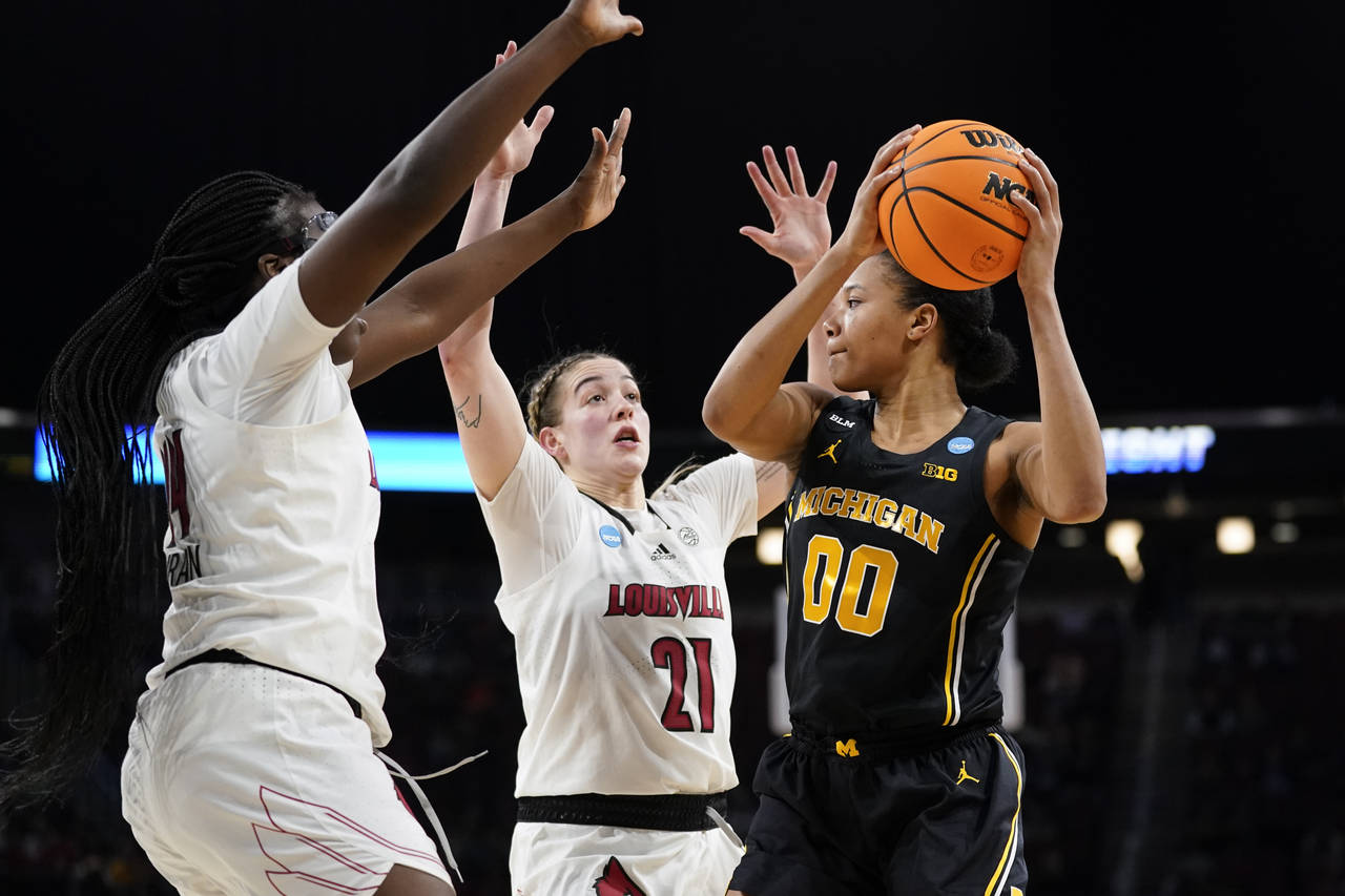Michigan forward Naz Hillmon (00) is defended by Louisville forward Olivia Cochran, left, and Emily...