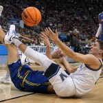
              Villanova 's Collin Gillespie, bottom right, scrambles for a loose ball with Delaware's Dylan Painter during the first half of a college basketball game in the first round of the NCAA tournament in Pittsburgh, Friday, March 18, 2022. (AP Photo/Gene J. Puskar)
            