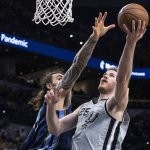 
              San Antonio Spurs center Jakob Poeltl (25) shoots against Memphis Grizzlies center Steven Adams (4) during the first half of an NBA basketball game Wednesday, March 30, 2022, in San Antonio. (AP Photo/Nick Wagner)
            