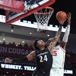 
              Cincinnati guard Jeremiah Davenport (24) grabs a rebound from Houston center Josh Carlton during the first half of an NCAA college basketball game Tuesday, March 1, 2022, in Houston. (AP Photo/Justin Rex)
            